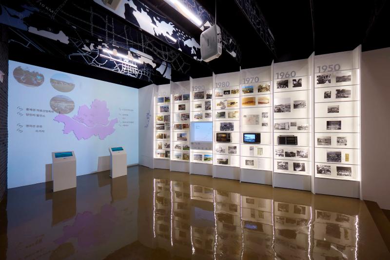 An exhibit showcasing the different decades of Seoul regeneration line the walls of the Seoul Urban Regeneration Gallery.