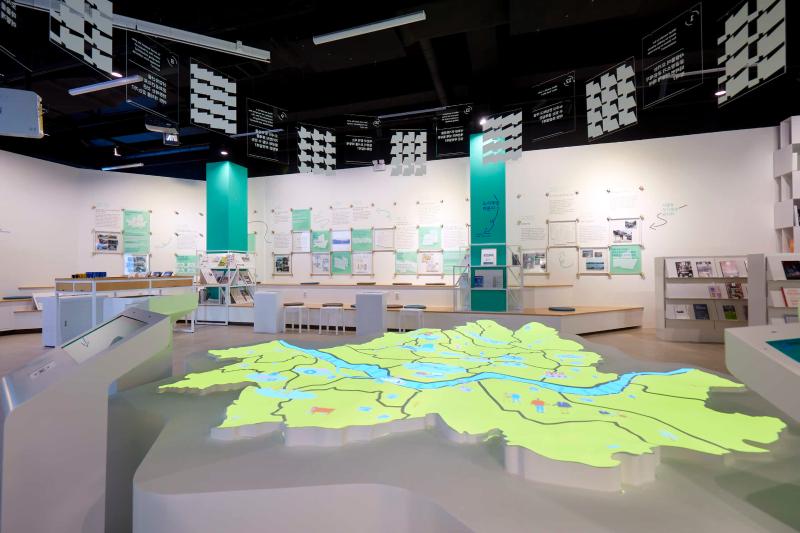 An illuminated map of Seoul lies in the middle of the room. On the walls are other exhibits within the Seoul Urban Regeneration Gallery.