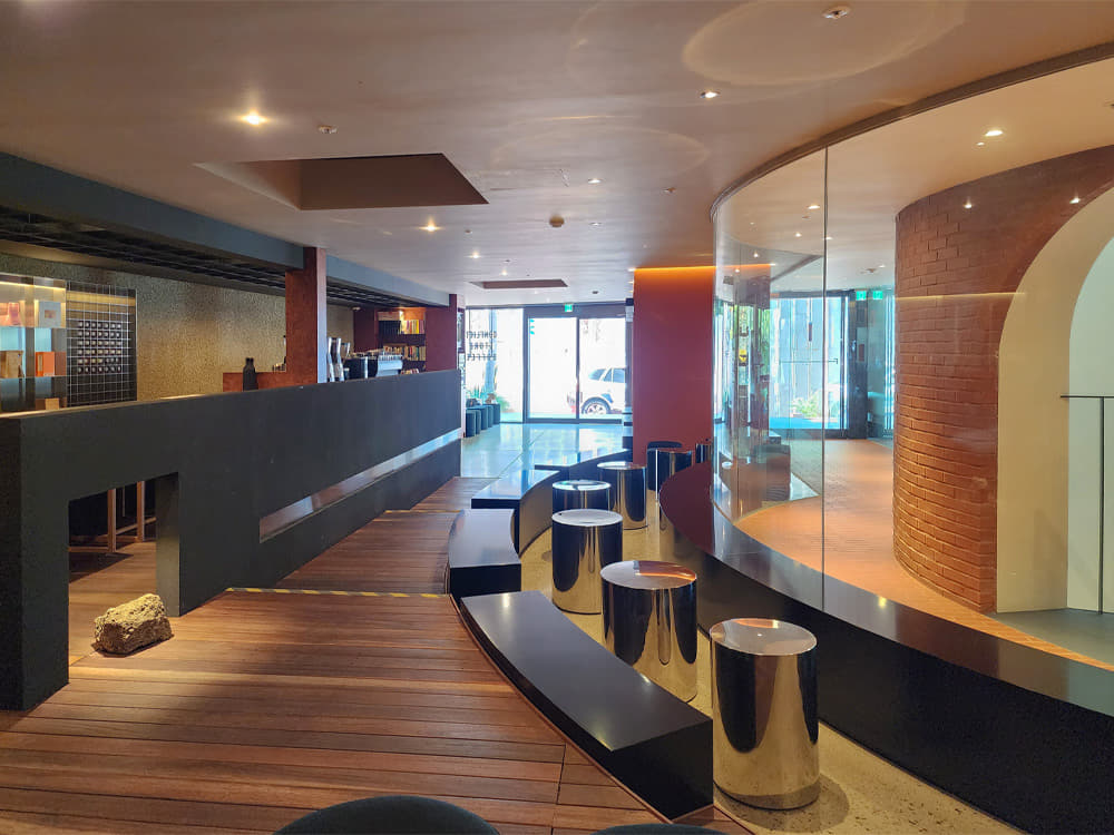 The cafe on the first floor of Figure and Ground, with a bar table and stools on the left and curved seating on the right