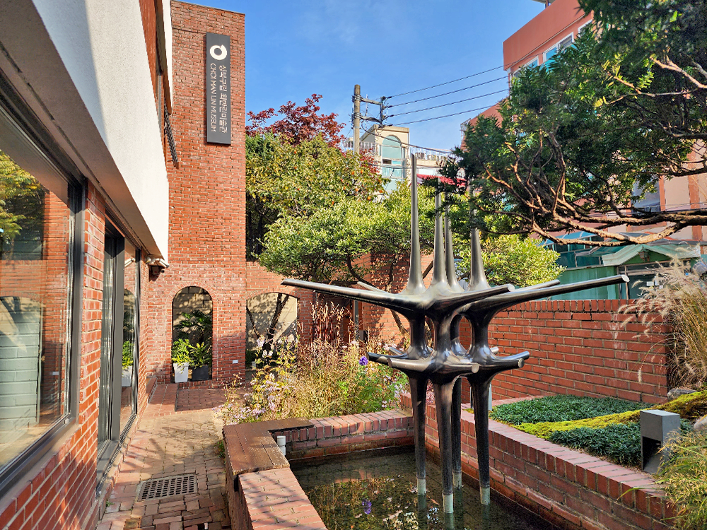 View of the garden in Choi Man Lin Museum, with sculptures placed among different plants