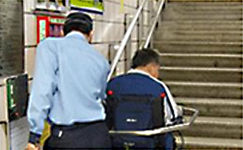 Station staff assisting passenger with wheelchair lift